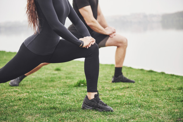 young bearded man and woman exercising together in morning